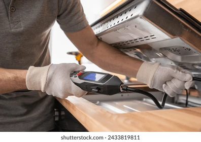 Technician checking gas connection with detector
